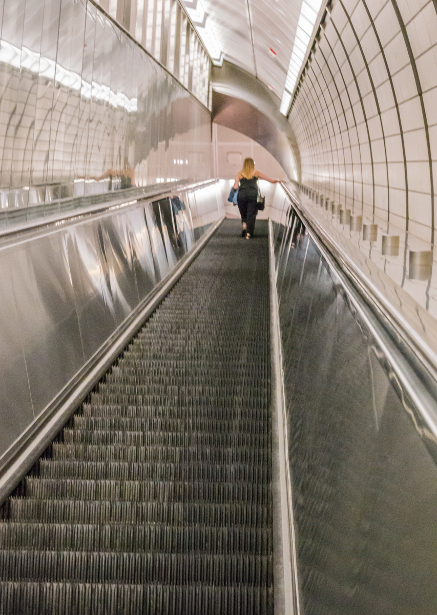 Woman ascending escalator in the 34th Street-Hudson Yards Subway Station, Manhattan, NY, USA | Photo by Mike Hudak