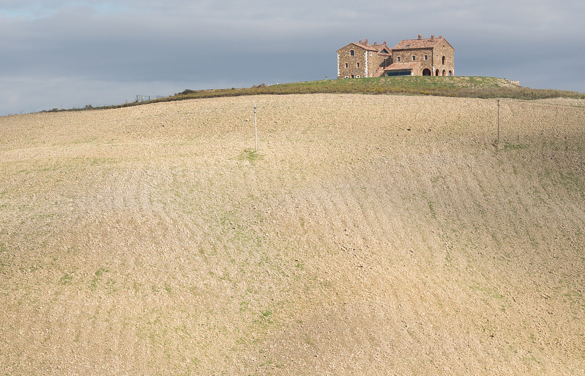 A farmhouse with cleared vineyard along the Via Francigena in Tuscana north of San Quirico d'Orcia, Italy | Photo by Mike Hudak