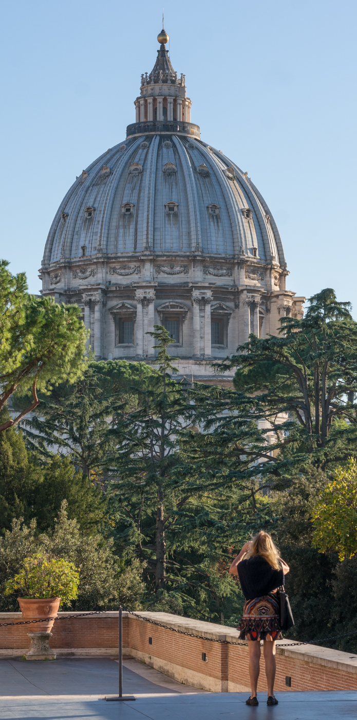 A woman photographs the dome of St. Peter's Basilica from Vatican Museums | Photo by Mike Hudak